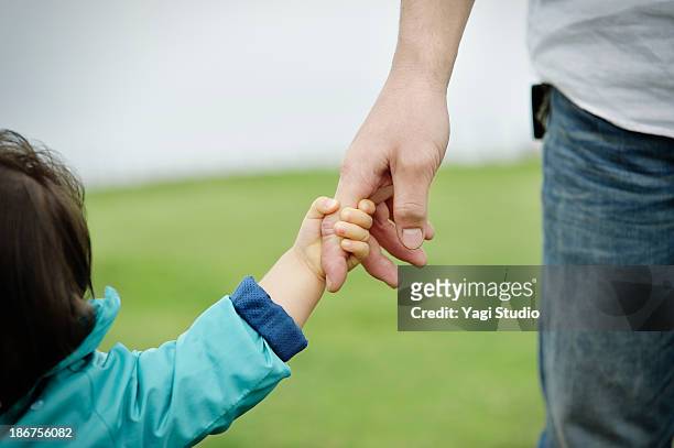 father and daughter holding hands - 手をつなぐ ストックフォトと画像