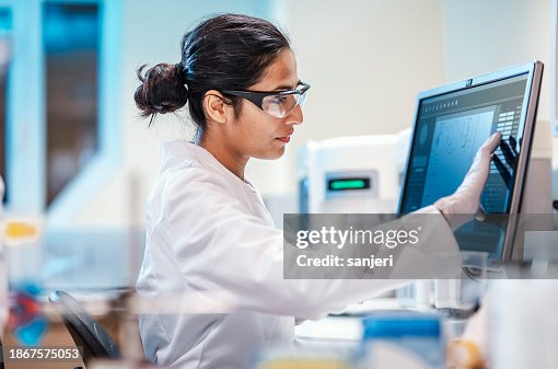 Scienziato femminile che lavora in laboratorio, usando il computer Scienziato femminile che lavora in laboratorio, usando il computer