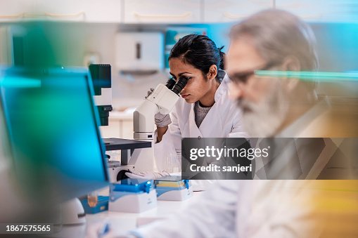Female Scientist Working in The Lab, Using Microscope Female Scientist Working in The Lab, Using Microscope