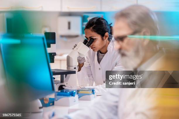 female scientist working in the lab, using microscope - clinic selective focus stock pictures, royalty-free photos & images