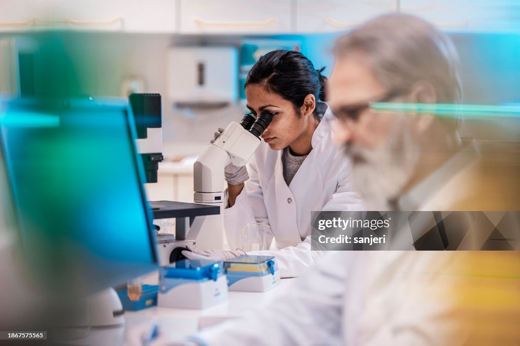 Female Scientist Working in The Lab, Using Microscope