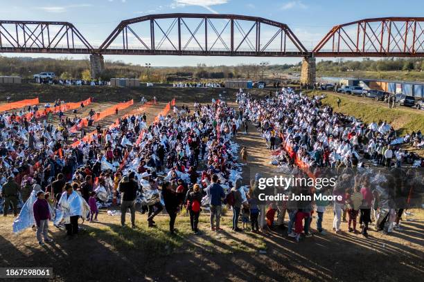 In an aerial view, thousands of immigrants, most wearing thermal blankets, await processing at a U.S. Border Patrol transit center on December 19,...