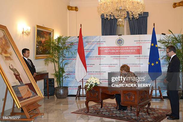 High Representative of the European Union for Foreign Affairs and Security Policy Catherine Ashton signs a document next to Indonesia's Foreign...