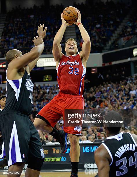Blake Griffin of the Los Angeles Clippers shoots over Chuck Hayes and Jason Thompson of the Sacramento Kings during the third quarter at Sleep Train...