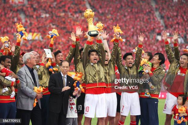 Head coach Marcello Lippi and Guangzhou Evergrande players celebrate with the trophy after defeating Wuhan Zall to win the 2013 Chinese Super League...