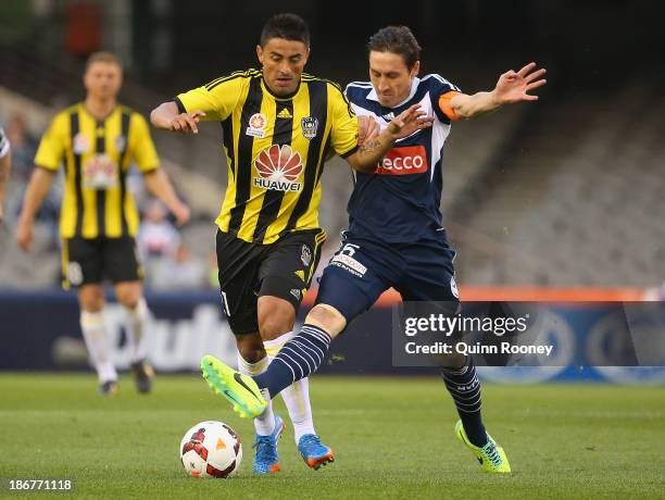 Carlos Hernandez of the Phoenix and Mark Milligan of the Victory contest for the ball during the round four A-League match between Melbourne Victory...