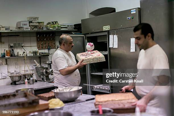 Lebanese pastry chef Idad Moussa Fakhro carries a cake in the bakery's pantry at Sonnenallee in Neukoelln district on November 02, 2013 in Berlin,...