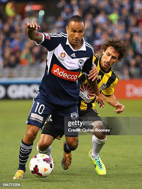 Archie Thompson of the Victory and Albert Riera of the Phoenix contest for the ball during the round four A-League match between Melbourne Victory...