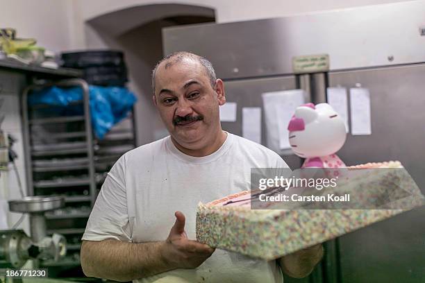 Lebanese pastry chef Idad Moussa Fakhro carries a cake in the bakery's pantry at Sonnenallee in Neukoelln district on November 02, 2013 in Berlin,...