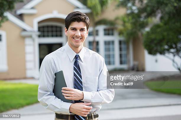 man standing in front of house - real estate agent male stock pictures, royalty-free photos & images