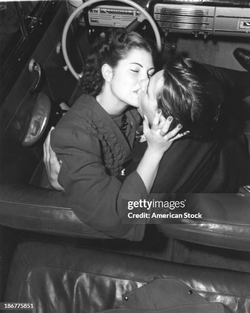 Couple kissing in front seat of convertible, 1945.