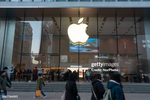 Citizens are walking past an Apple store in Shanghai, China, on December 22, 2023.