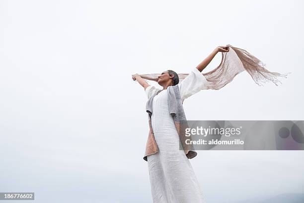 senior woman feeling happy - woman flying scarf stock pictures, royalty-free photos & images