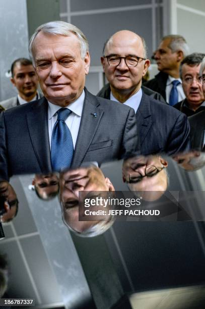 French Prime Minister Jean-Marc Ayrault visits a Focal factory flanked by French Economy, Finance and Foreign Trade Minister Pierre Moscovici , on...