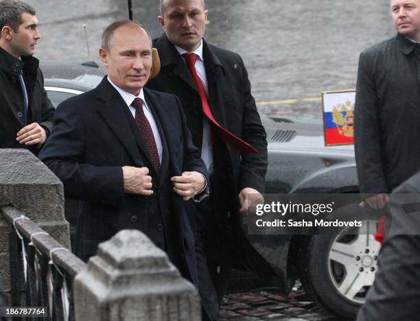 Russian President Vladimir Putin surrounded by bodyguards attends a wreath laying ceremony at the monument of Minin and Pozharsky in Red Square on...