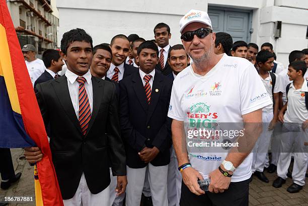 In this handout image provided by Laureus, Sir Ian Botham with students from Trinity College before the fourth day of Beefy's Big Sri Lanka walk 2013...