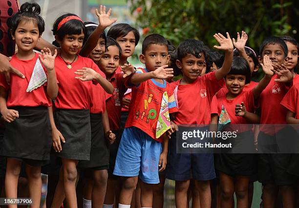 In this handout image provided by Laureus, Children wave during the fourth day of Beefy's Big Sri Lanka walk 2013 walk from Kandy to Pinawella on...