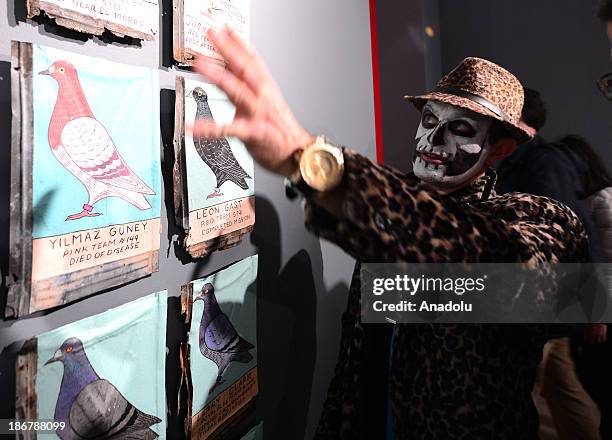 Brooklyn artist Duke Riley points out the cigar carrying pigeons during 'Trading with the Enemy' exhibition on November 1, 2013 in New York City....