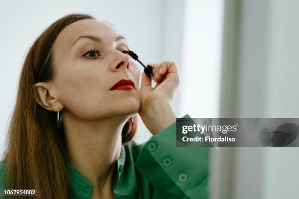 a woman getting dressed in a green and red costume. - wishful skin imagens e fotografias de stock