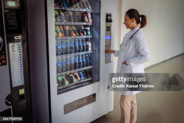 female doctor taking a break for lunch - verkoopautomaat stockfoto's en -beelden