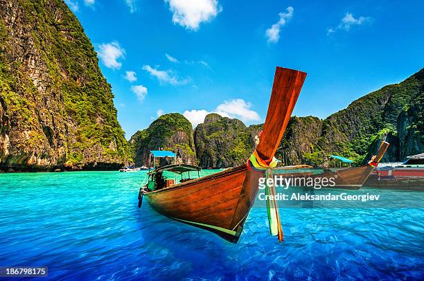 a longtail wooden boat at maya bay, thailand - longtailboot stockfoto's en -beelden