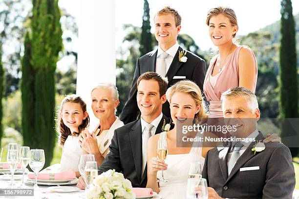 newlywed couple with family and wedding guests at reception - outdoor wedding stock pictures, royalty-free photos & images