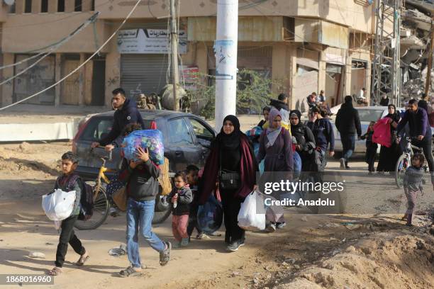 Palestinians, including children, leave their homes to escape Israeli bombardments and head towards the city of Deir al-Balah, after Israeli forces...