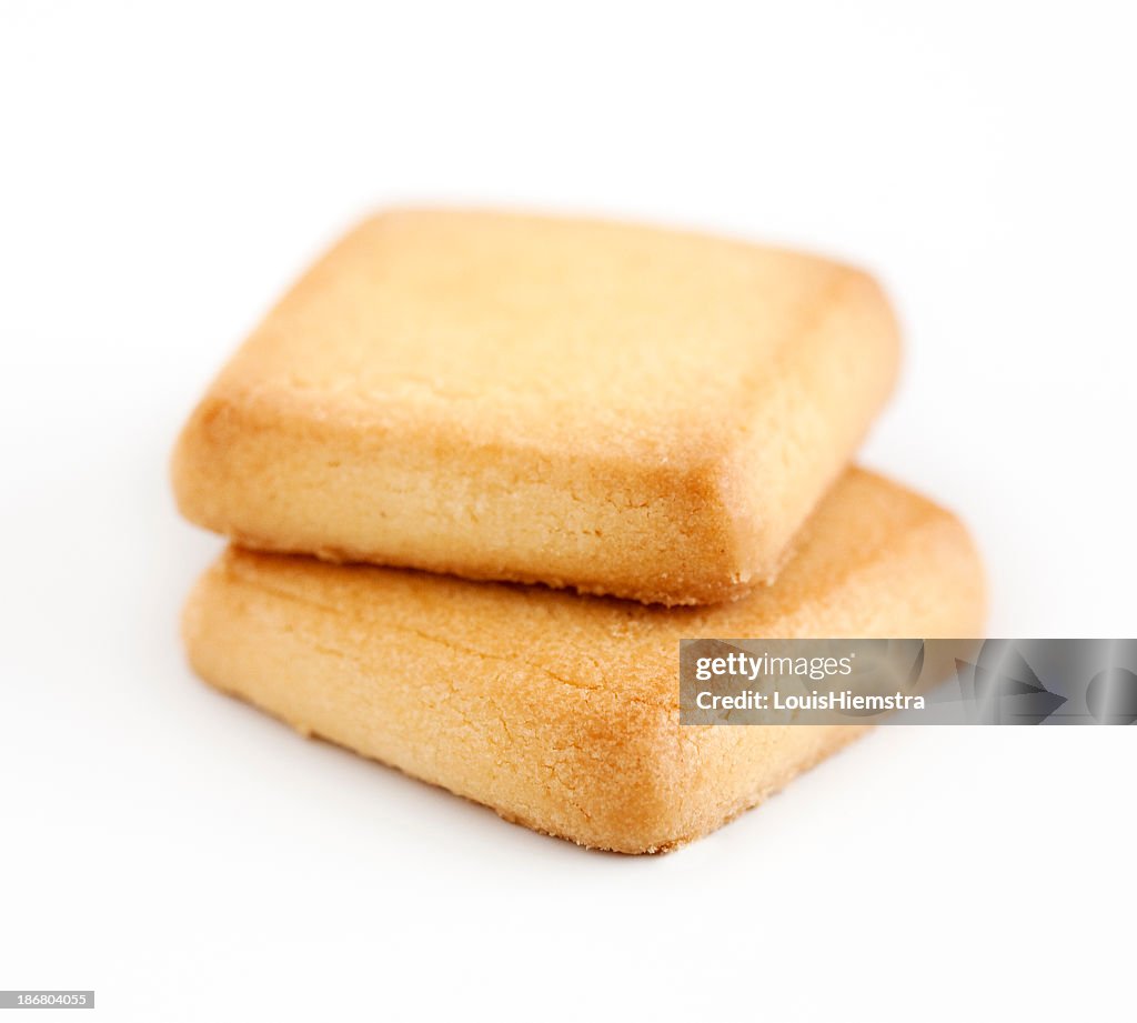 Two square shortbread cookies on a white background