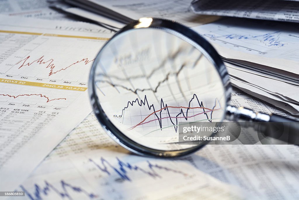 Magnifying glass on top of financial market info