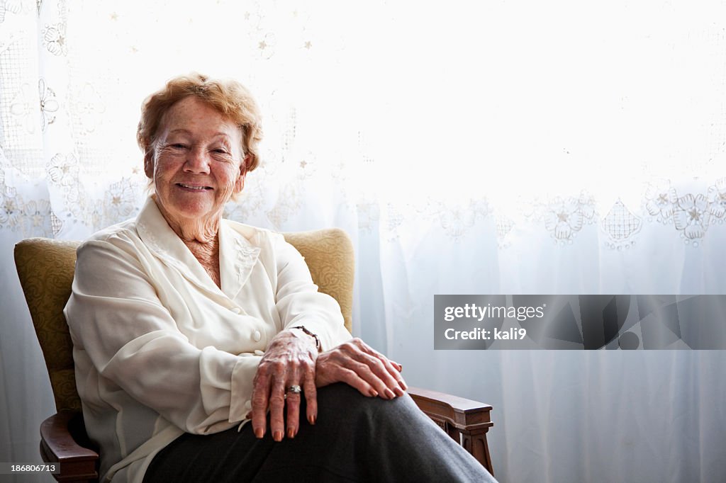 Senior Frau im Sessel zu Hause