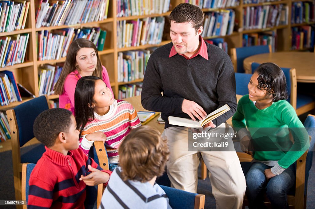 Teacher or librarian reading to group of children