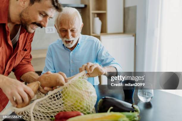 son helping his father - uitpakken activiteit stockfoto's en -beelden