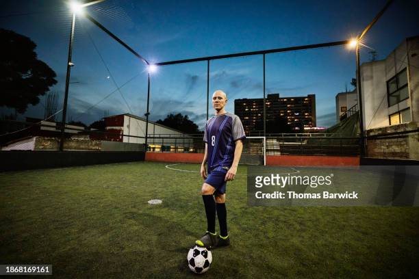 wide shot soccer player standing with ball on rooftop field at night - mexico city at night stock pictures, royalty-free photos & images