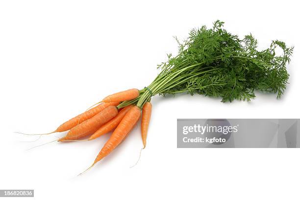 bundle of small carrots on white background - carrot stockfoto's en -beelden