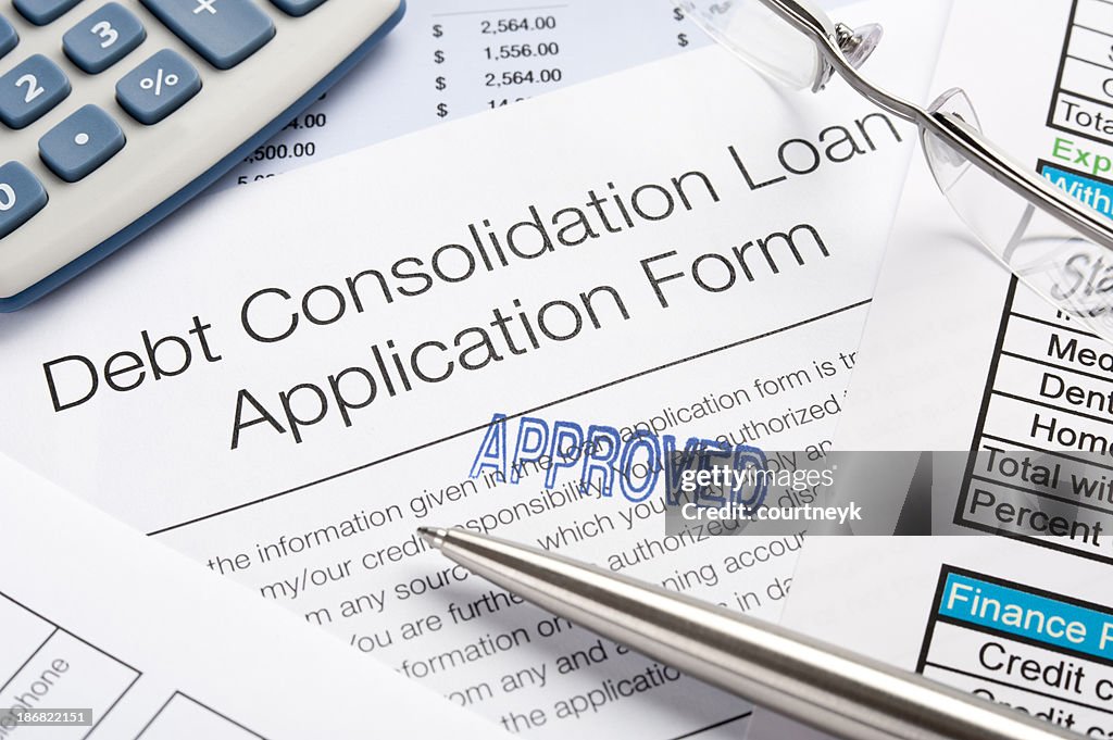 Approved Debt Consolidation Loan Application Form with pen, calc