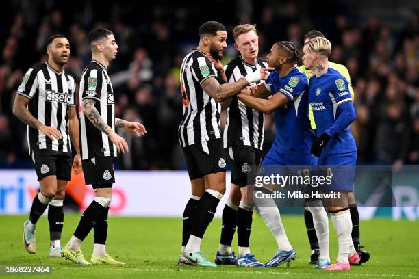 Jamaal Lascelles of Newcastle United clashes with Christopher Nkunku and Mykhaylo Mudryk of Chelsea during the Carabao Cup Quarter Final match...