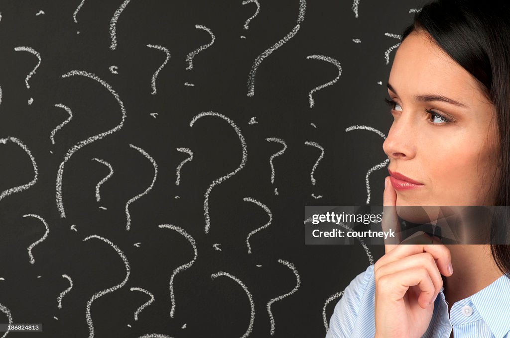 Woman contemplating question marks