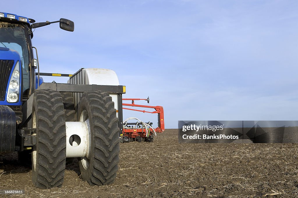 Grand tracteur et pot sur Tilled champ de maïs