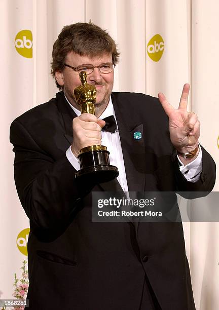 Director Michael Moore poses with his Best Documentary Feature award for "Bowling For Columbine" backstage during the 75th Annual Academy Awards at...