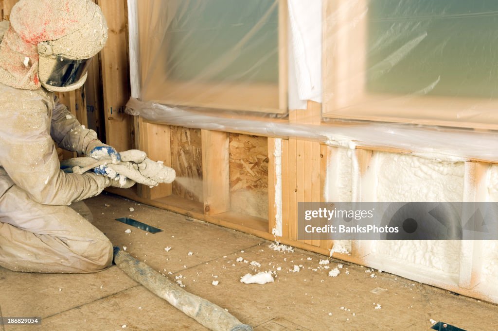 Trabalhador da Construção Civil Pulverizar expansível espuma de isolamento entre pitons de Parede