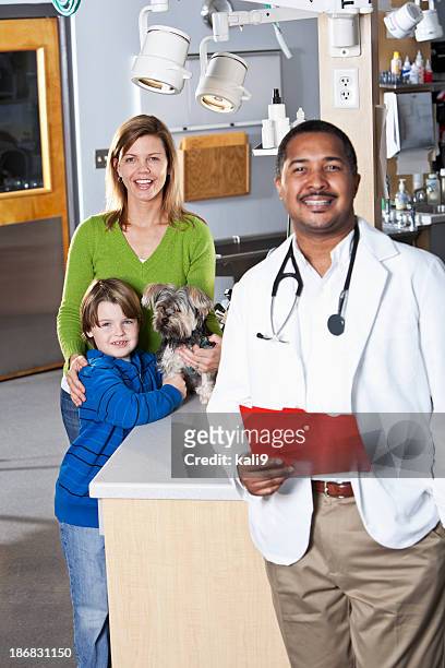 boy and mother taking pet dog to vet - yorkshire terrier vet stock pictures, royalty-free photos & images