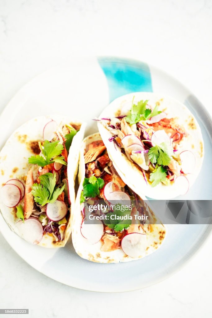 Fish (salmon) tacos on a plate on white background