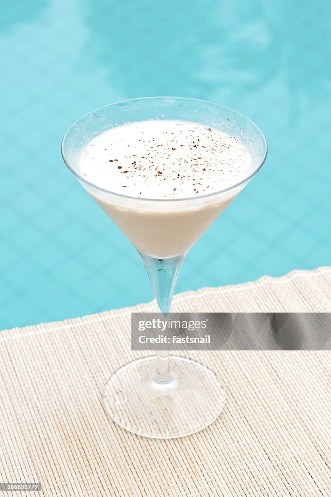 Alexander cóctel clásico Brandy, cerca de waterpool en la estera