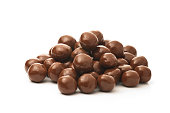 Dipped chocolate peanuts in a pile on a white background