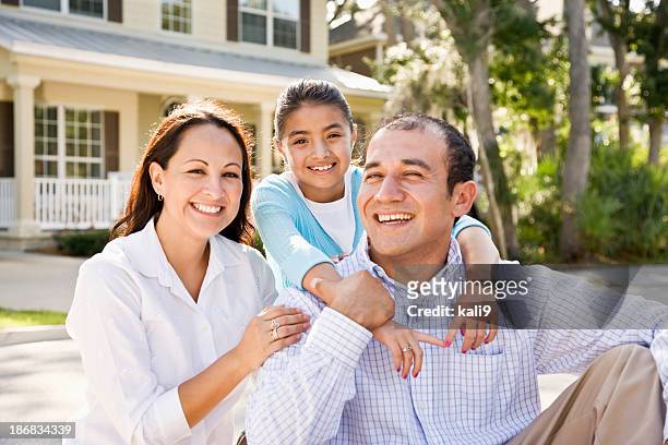 portrait happy hispanic family sitting with house in background - in front of stock pictures, royalty-free photos & images