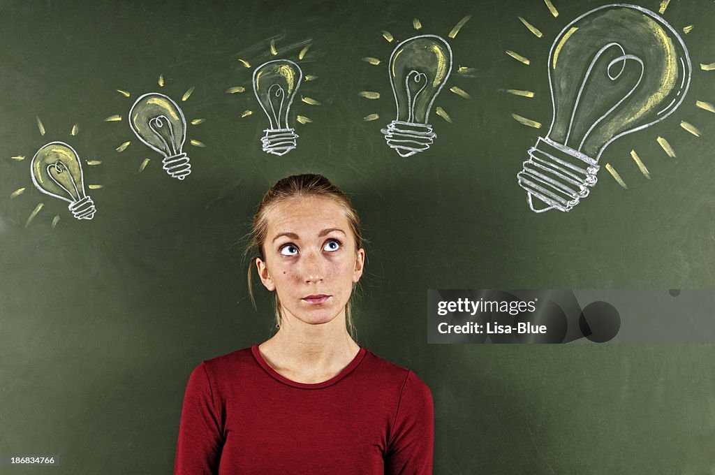 Young Woman Looking at Sketched Light Bulbs