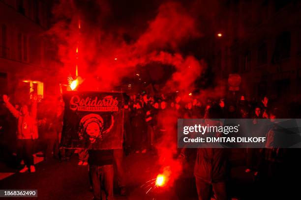 Protesters light flares during a solidarity march for the defence of immigrants against France's new immigration law at Theodor Herzl Square, in...