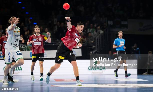 Mijajlo Marsenic of the Fuechsen Berlin throws the ball in front of Maciej Gebala of SC DHfK Leipzig during the game between Fuechse Berlin and SC...