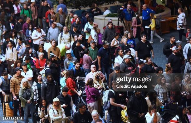 Passengers wait in the Transportation Security Administration screening line at Orlando International Airport ahead of the Christmas holiday travel...