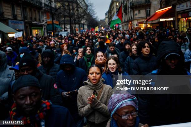 Protesters shout slogans during a solidarity march for the defence of immigrants against France's new immigration law in Paris on December 22, 2023....